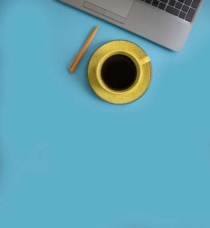 cup of coffee, laptop on a colored background