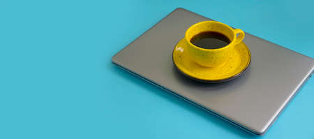 cup of coffee, laptop on a colored backgroundの写真素材