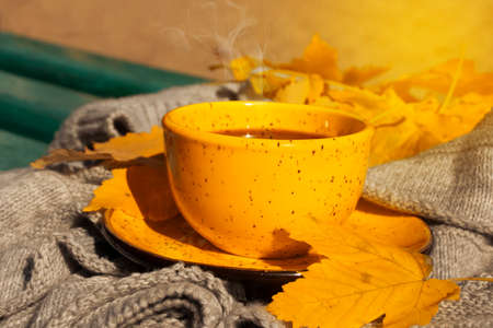 cup of coffee, autumn maple leaf, scarf on a wooden background,の写真素材