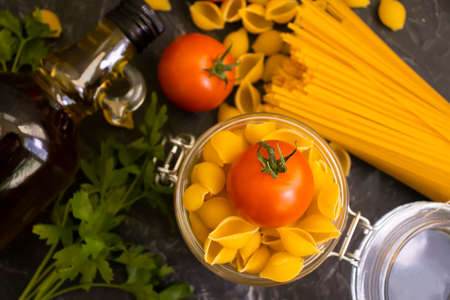dry pasta, tomato, oil on a concrete backgroundの写真素材