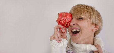 happy woman with a cup of coffee on a light backgroundの写真素材