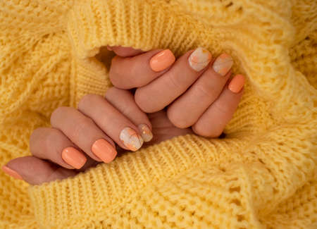 female hands beautiful manicure warm fabric sweater yellow