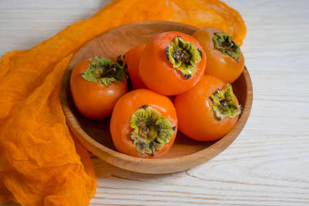 persimmon fruit on wooden backgroundの写真素材