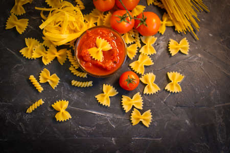 dry pasta, sauce, tomato on a concrete backgroundの写真素材