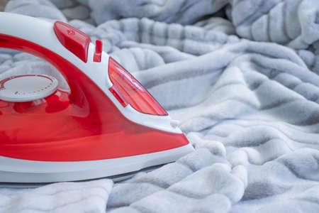 electric iron on a warm cloth backgroundの写真素材