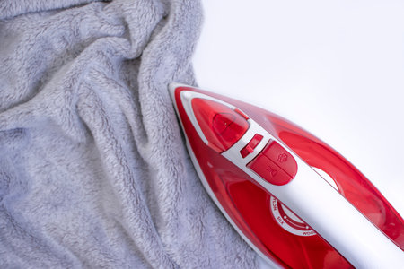 electric iron on a warm cloth backgroundの写真素材