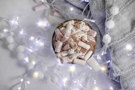 cup with marshmallows, garland festive background