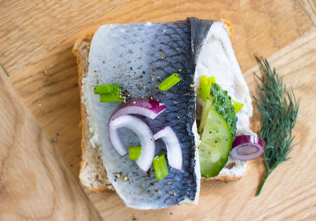 herring sandwich blue onion on wooden background