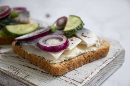 herring sandwich blue onion on wooden background