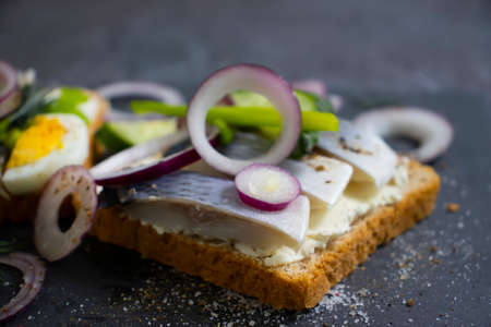 herring sandwich blue onion on wooden background
