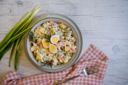 olivier salad, green onions on wooden backgroundの写真素材