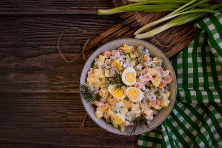 olivier salad, green onions on wooden backgroundの写真素材
