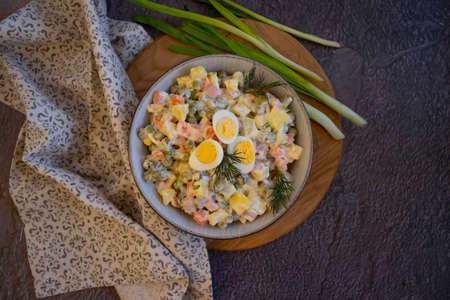 olivier salad, green onions on wooden backgroundの写真素材