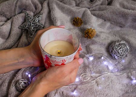female hands holding a candle christmas backgroundの写真素材