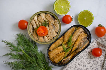 sprats in a can, fresh dill on wooden background