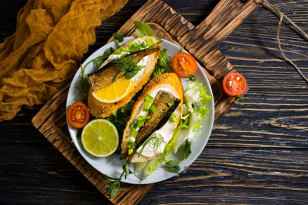 sprats in a can, fresh dill on wooden backgroundの写真素材