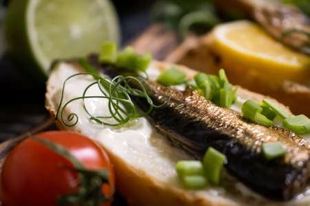 sprats in a can, fresh dill on wooden background