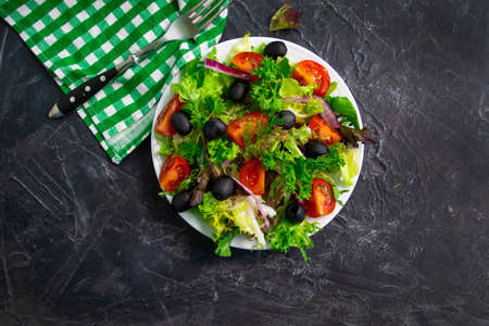 lettuce leaves, tomato, olives in a plate close-upの写真素材