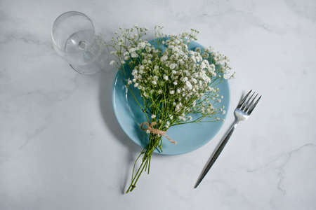 gypsophila flower plate in a vase on a brick background