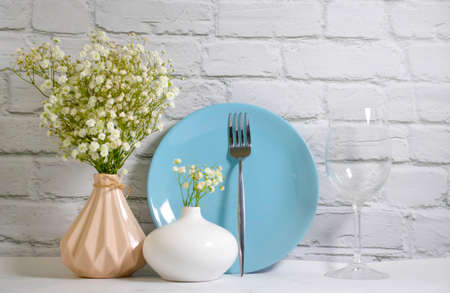 gypsophila flower plate in a vase on a brick background