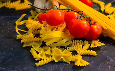 raw pasta, cherry tomato on a concrete backgroundの写真素材