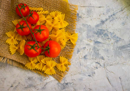 raw pasta, cherry tomato on a concrete backgroundの写真素材