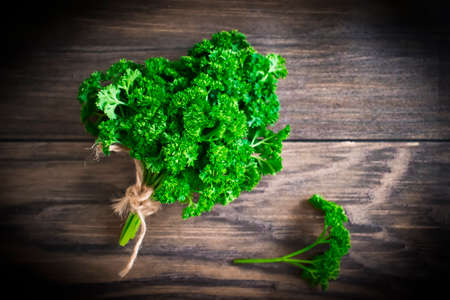 Parsley bunch on wooden background green organicの写真素材