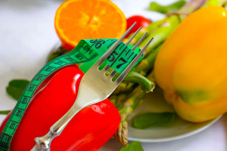 fresh vegetables, measuring tape, fork on wooden background
