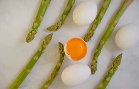 asparagus, raw egg on old background