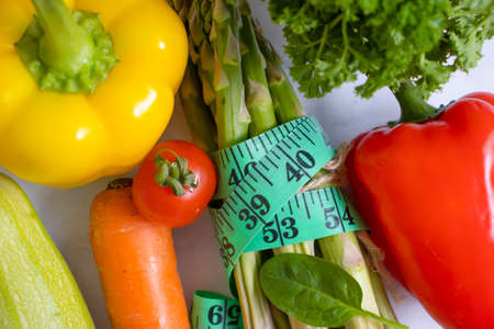 fresh vegetables, measuring tape on wooden backgroundの写真素材
