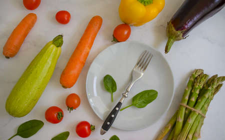 Fresh different vegetables, empty plate