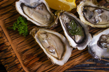 fresh oysters, lemon on wooden background gourmetの写真素材