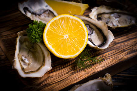 fresh oysters, lemon on wooden background gourmetの写真素材