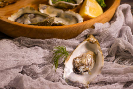 fresh oysters, lemon on wooden background gourmetの写真素材
