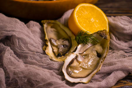 fresh oysters, lemon on wooden background gourmetの写真素材
