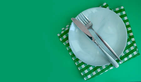 Empty Plate, Fork, Knife on a Colored Backgroundの写真素材