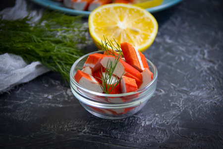 crab sticks in a plate on a dark background