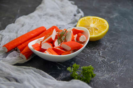 crab sticks in a plate on a dark background