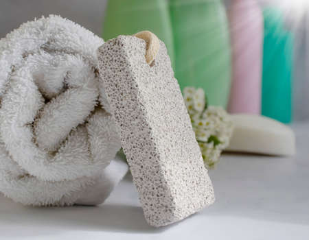 pumice for feet, towel, flower, soap on a light backgroundの写真素材