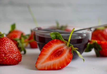 Strawberry jam, fresh berries on a light background