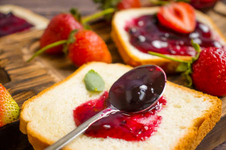 Strawberry jam in a glass of bread on an old backgroundの写真素材