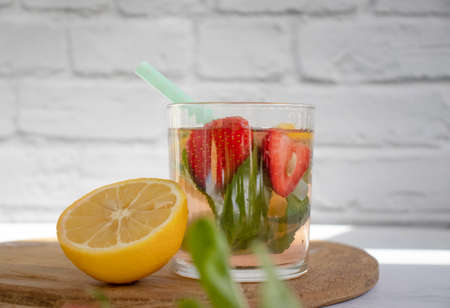 Lemonade with strawberries, mint, lemon on a light backgroundの写真素材