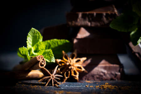 Black chocolate, mint leaf on a dark background