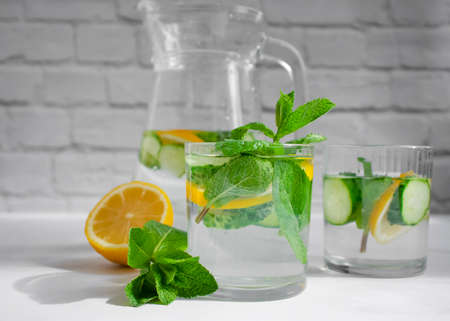Water with lemon, cucumber, mint on a light background