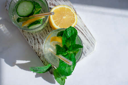 Water with lemon, cucumber, mint on a light backgroundの写真素材