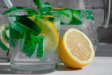 Water with lemon, cucumber, mint on a light backgroundの写真素材