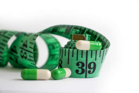 Measuring tape, pills on a light backgroundの写真素材