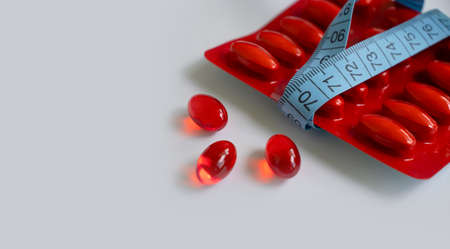 Pills, centimeter tape on a light backgroundの写真素材