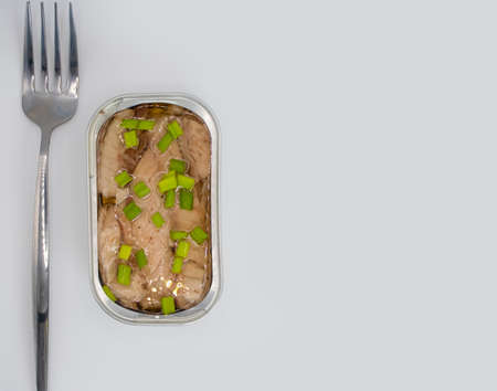 Open canned fish on a light background