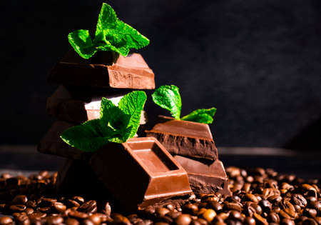 Chocolate, mint leaf, coffee beans on a dark backgroundの写真素材